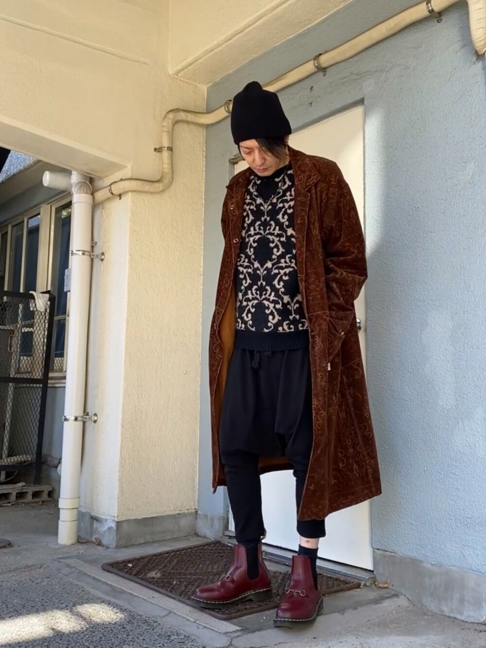 ブラック系のニット/セーター、ブラウン系のその他アウター、ブラック系のその他パンツを着用したメンズの冬コーディネートの5枚目の写真