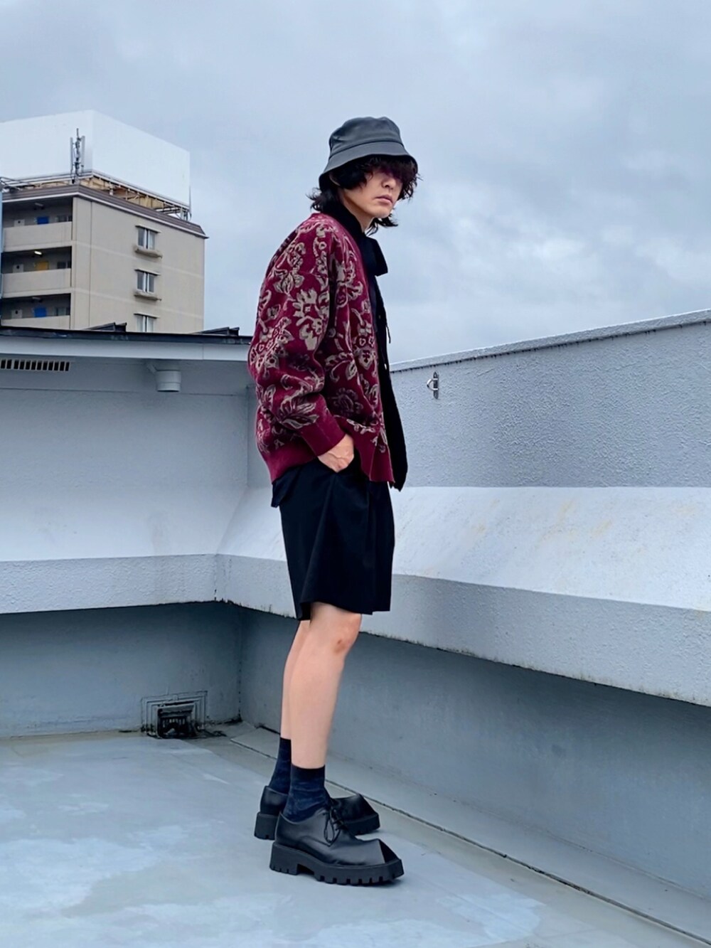 レッド系のカーディガン/ボレロ、ブラック系のシャツ/ブラウス、ブラック系のスラックスを着用したメンズの秋コーディネートの2枚目の写真