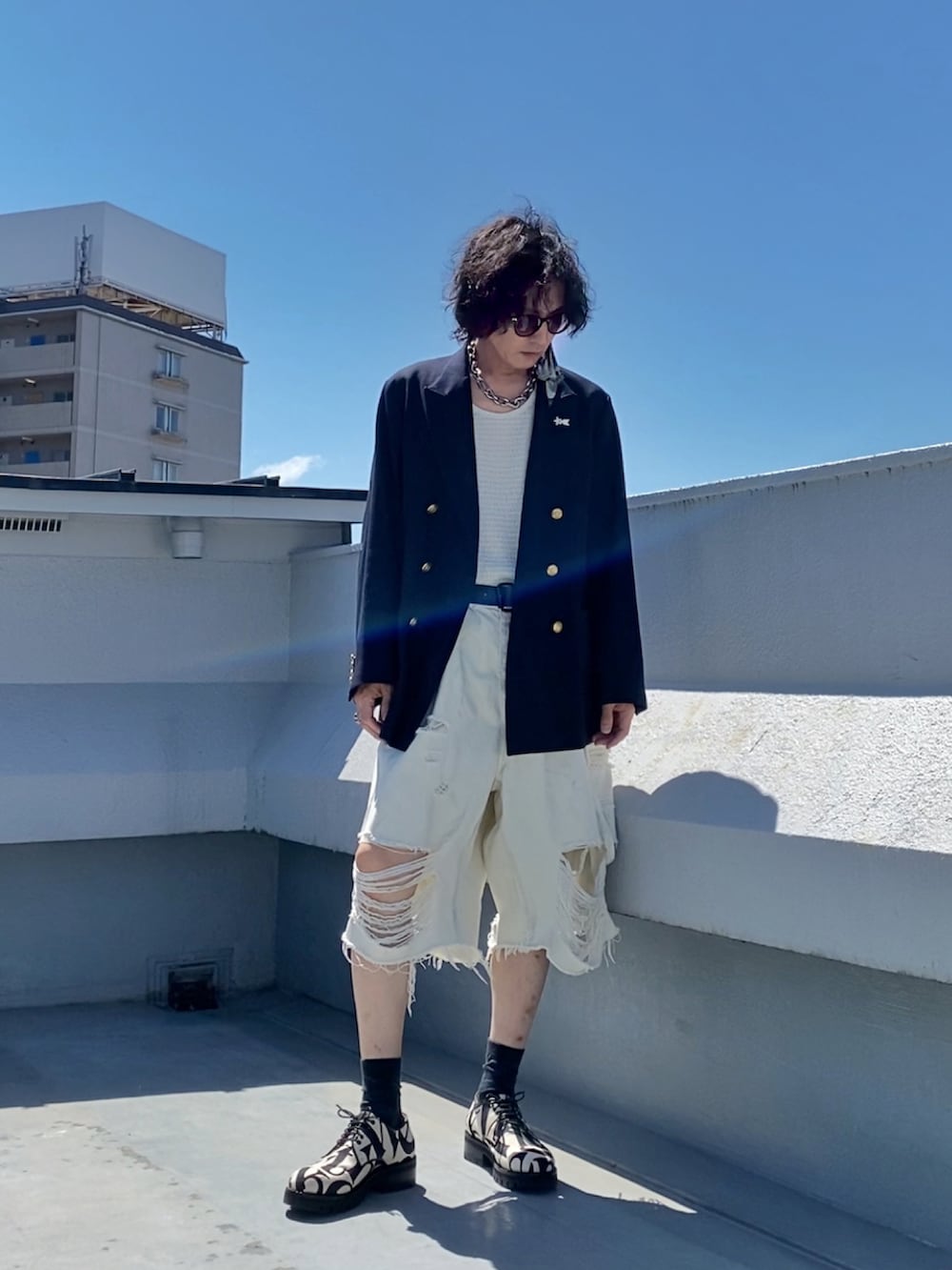 ホワイト系のタンクトップ、ブルー系のテーラードジャケット、ホワイト系のデニムパンツを着用したメンズの夏コーディネートの2枚目の写真