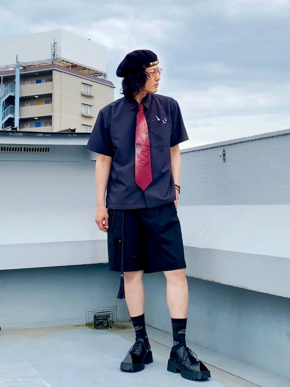 ブラック系のスラックス、ブラック系のシャツ/ブラウス、レッド系のネクタイを着用したメンズの夏コーディネートの5枚目の写真