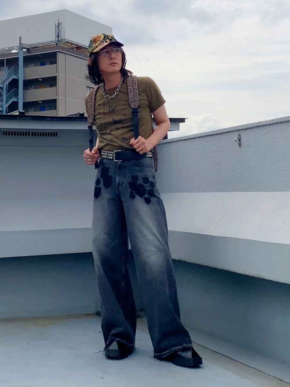 ブラック系のデニムパンツ、ベージュ系のTシャツ/カットソー、ブラック系のドレスシューズを着用したメンズの夏コーディネートの2枚目の写真