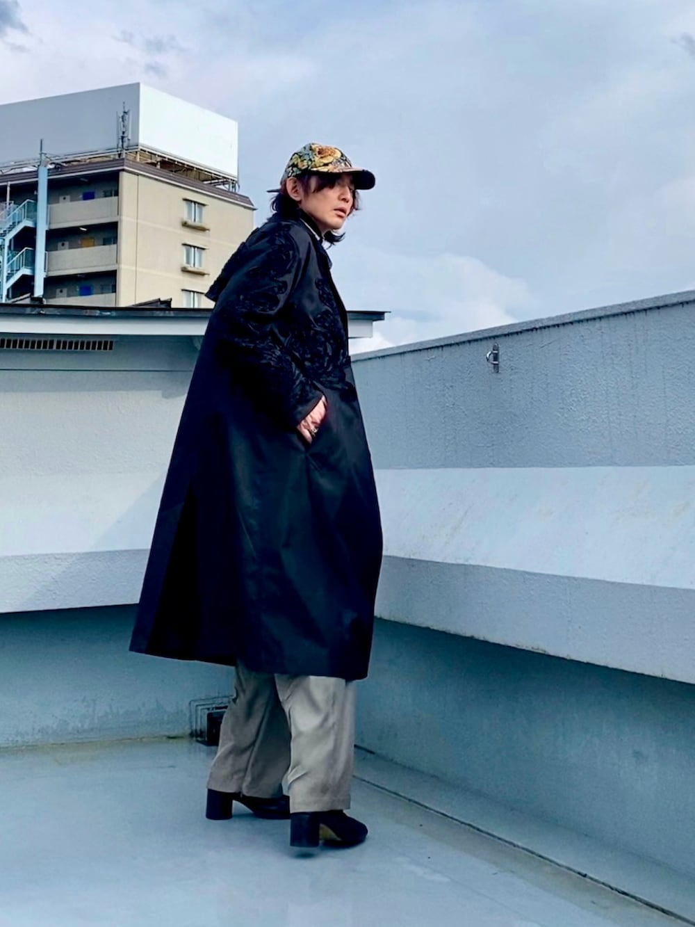 ブラック系のブーツ、ホワイト系のシャツ/ブラウス、ブラック系のステンカラーコートを着用したメンズの春コーディネートの3枚目の写真