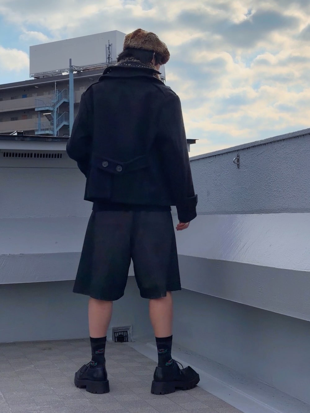 レッド系のニット/セーター、ブラック系のピーコート、ブラック系のその他パンツを着用したメンズの冬コーディネートの4枚目の写真