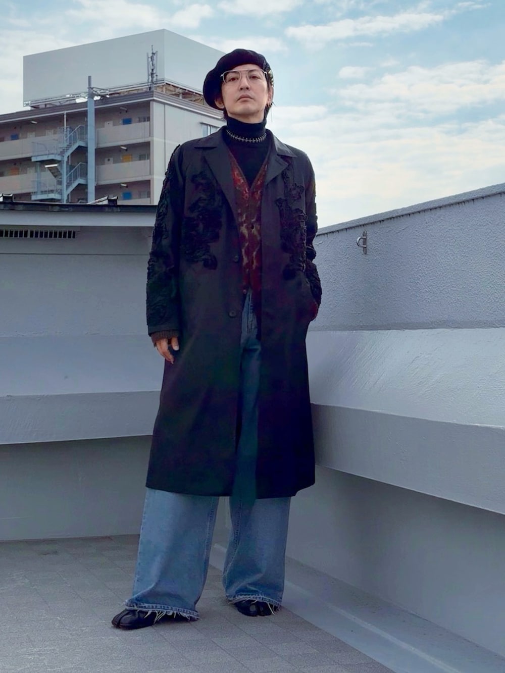 ブルー系のデニムパンツ、ブラック系のブーツ、ブラック系のニット/セーターを着用したメンズの冬コーディネートの5枚目の写真