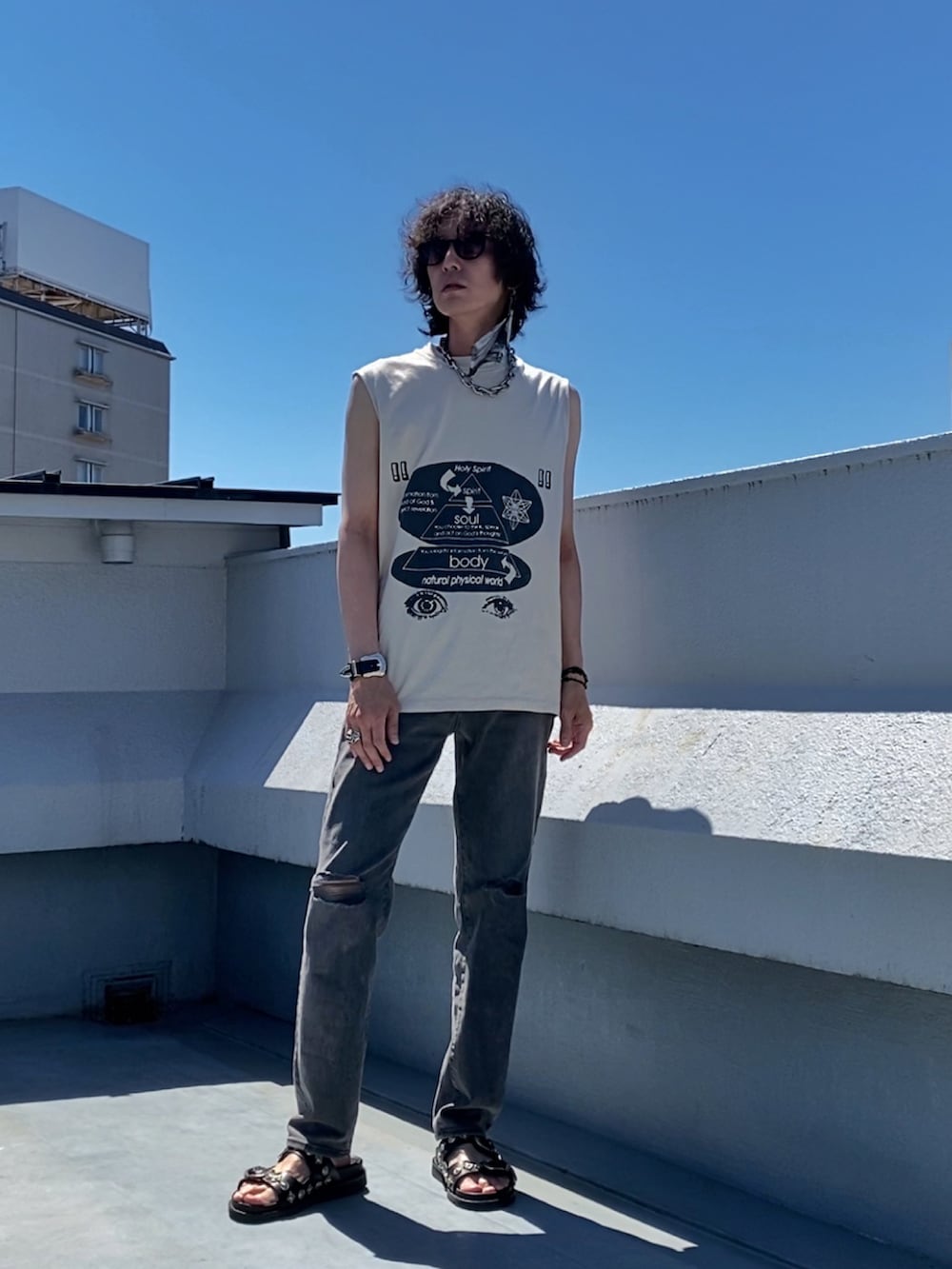 ベージュ系のTシャツ/カットソー、グレー系のデニムパンツ、ブラック系のサンダルを着用したメンズの夏コーディネートの4枚目の写真