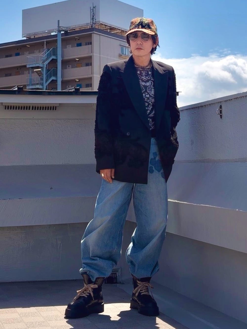 ブラック系のブーツ、ブルー系のデニムパンツ、ブラック系のTシャツ/カットソーを着用したメンズの春コーディネートの4枚目の写真