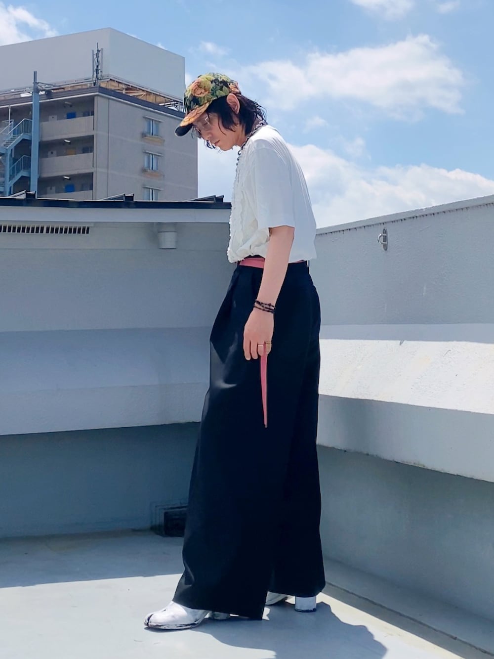 ホワイト系のTシャツ/カットソー、ブラック系のスラックス、ホワイト系のブーツを着用したメンズの夏コーディネートの4枚目の写真