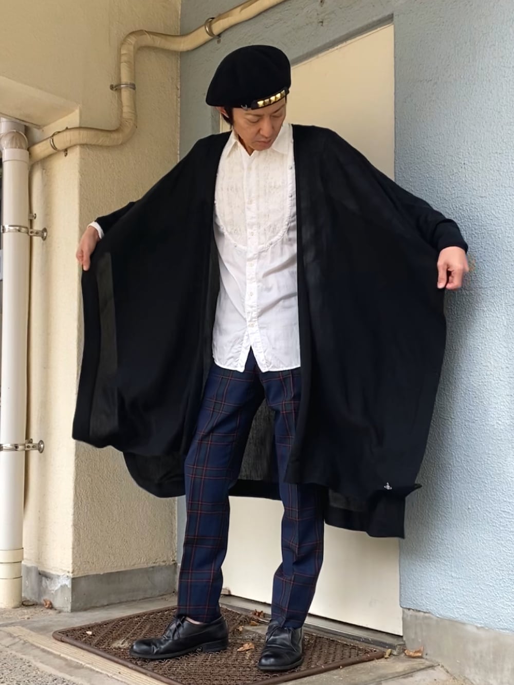 ブラック系のカーディガン/ボレロ、グリーン系のスラックス、ブラック系のドレスシューズを着用したメンズの秋コーディネートの4枚目の写真