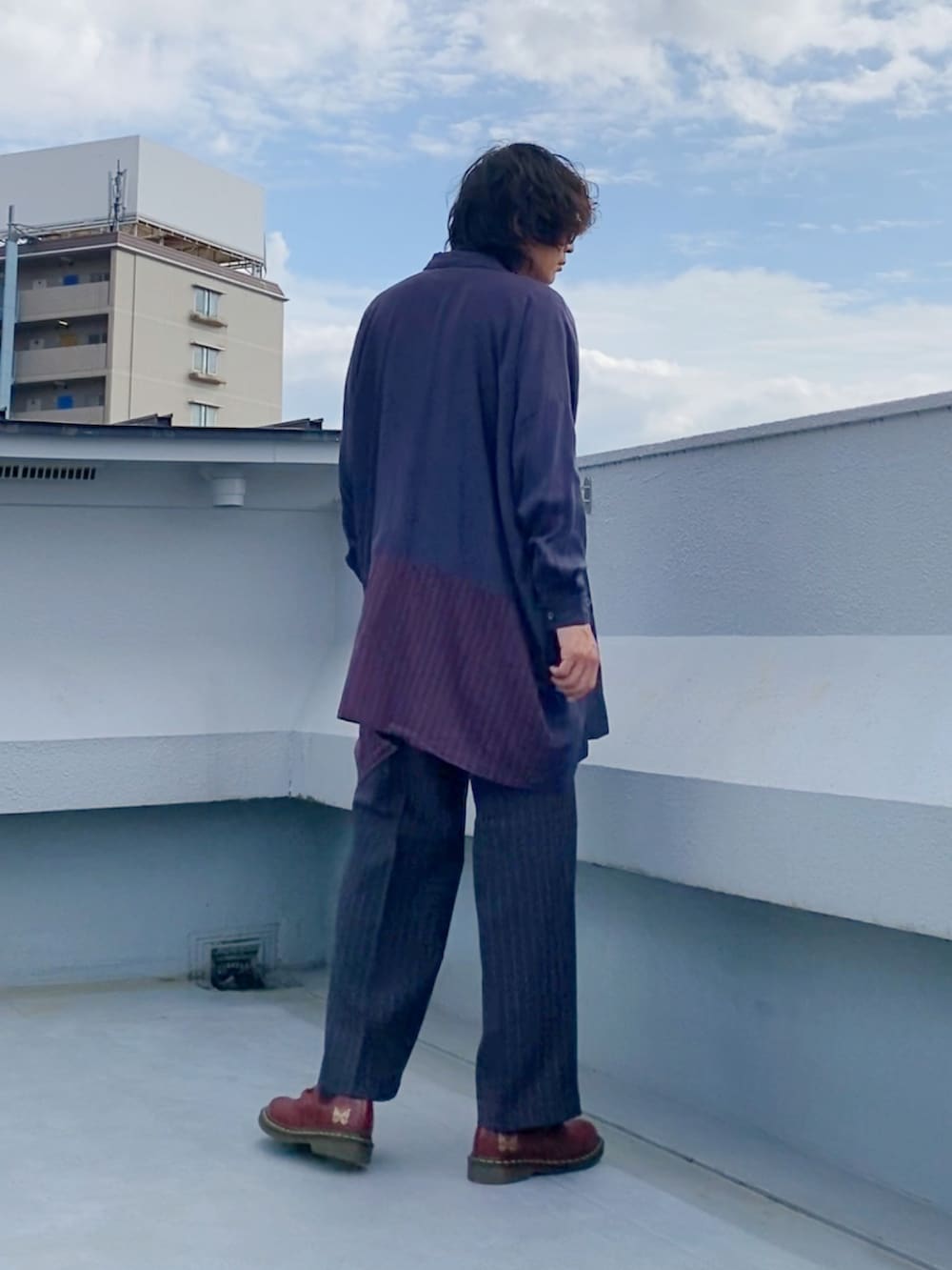 ブラック系のTシャツ/カットソー、ブルー系のシャツ/ブラウス、グレー系のスラックスを着用したメンズの秋コーディネートの4枚目の写真