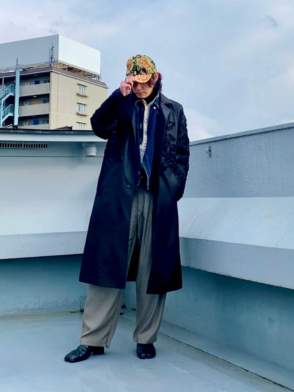 ブラック系のブーツ、ホワイト系のシャツ/ブラウス、ブラック系のステンカラーコートを着用したメンズの春コーディネートの2枚目の写真