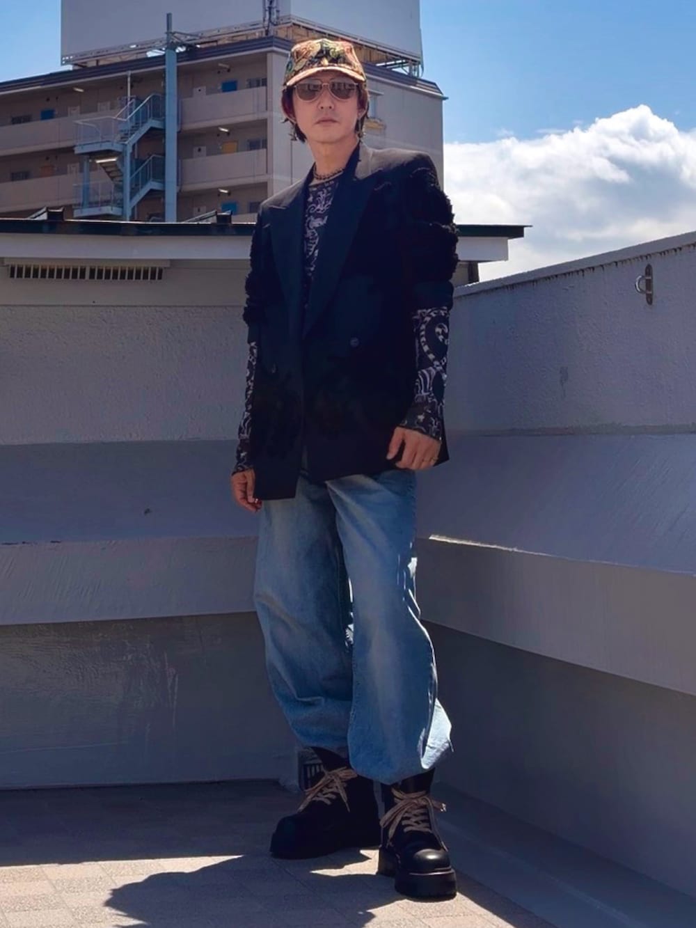ブラック系のブーツ、ブルー系のデニムパンツ、ブラック系のTシャツ/カットソーを着用したメンズの春コーディネートの5枚目の写真