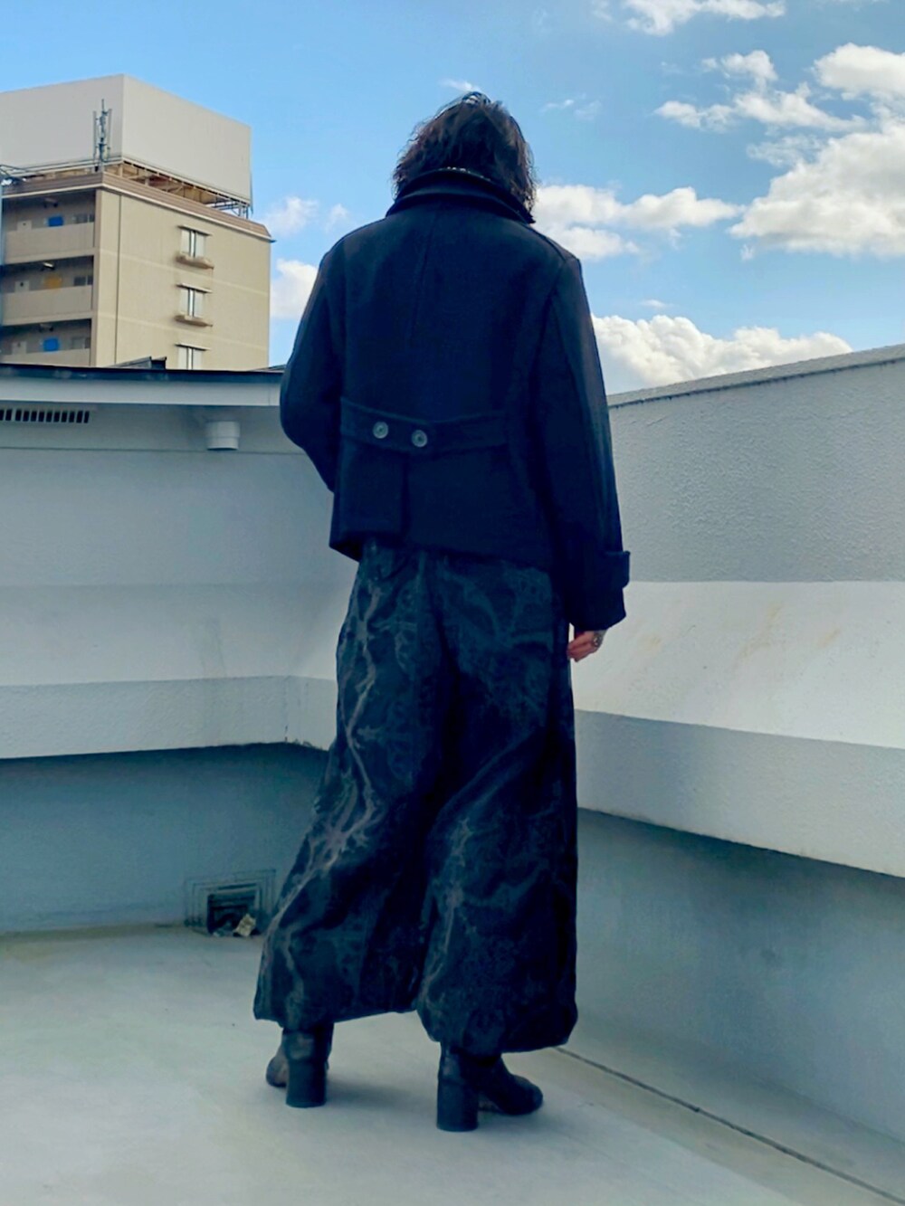 ブラック系のピーコート、ブラック系のニット/セーター、ブラック系のその他パンツを着用したメンズの冬コーディネートの4枚目の写真