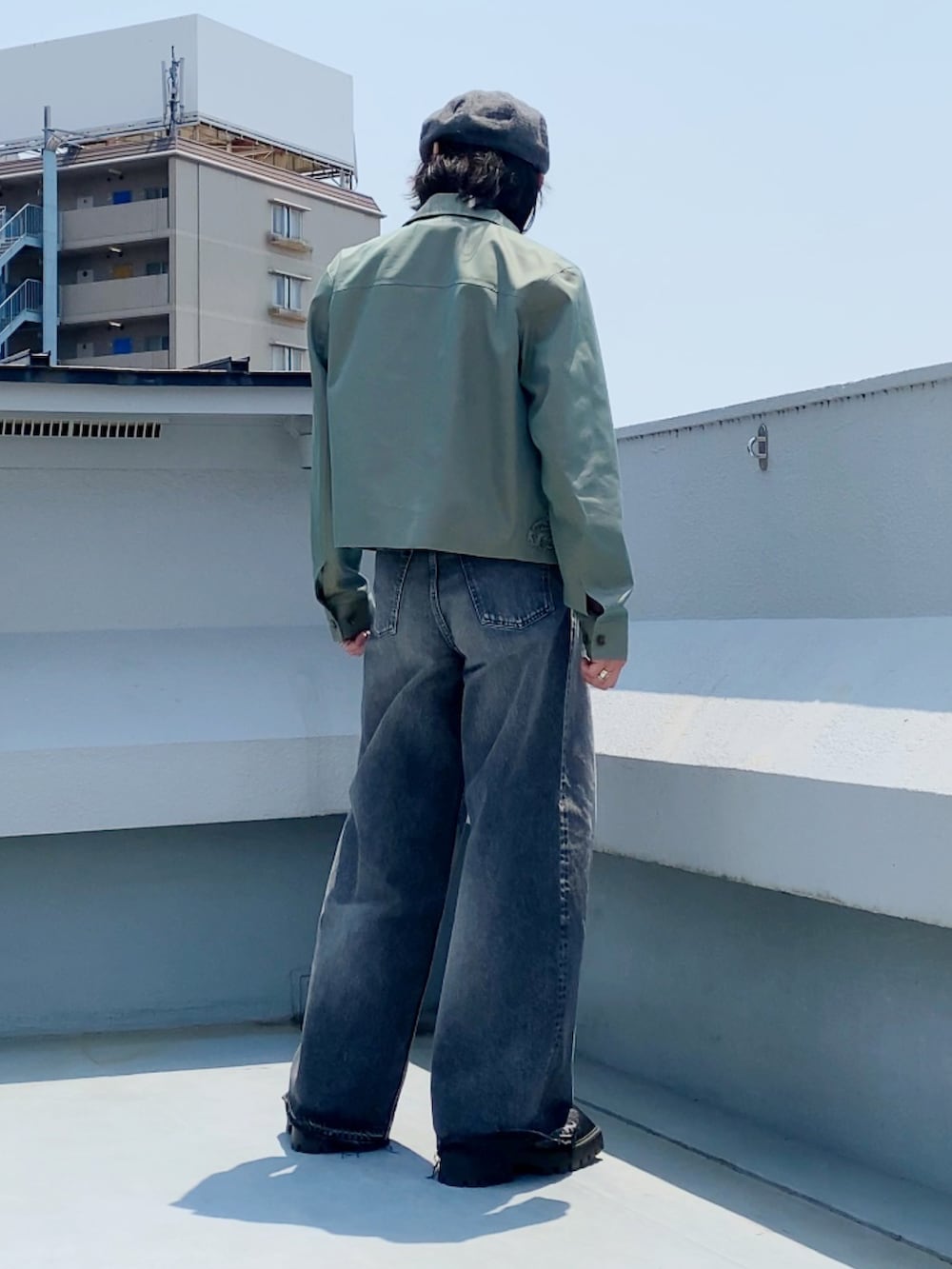 グリーン系のブルゾン、ブラック系のTシャツ/カットソー、ブラック系のデニムパンツを着用したメンズの夏コーディネートの5枚目の写真