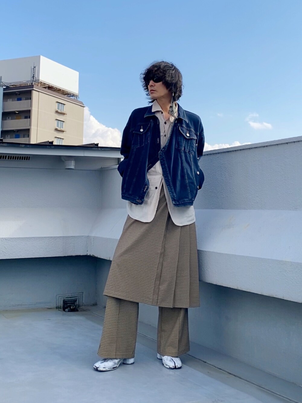 ブルー系のデニムジャケット、ベージュ系のスカート、ベージュ系のスラックスを着用したメンズの秋コーディネートの3枚目の写真