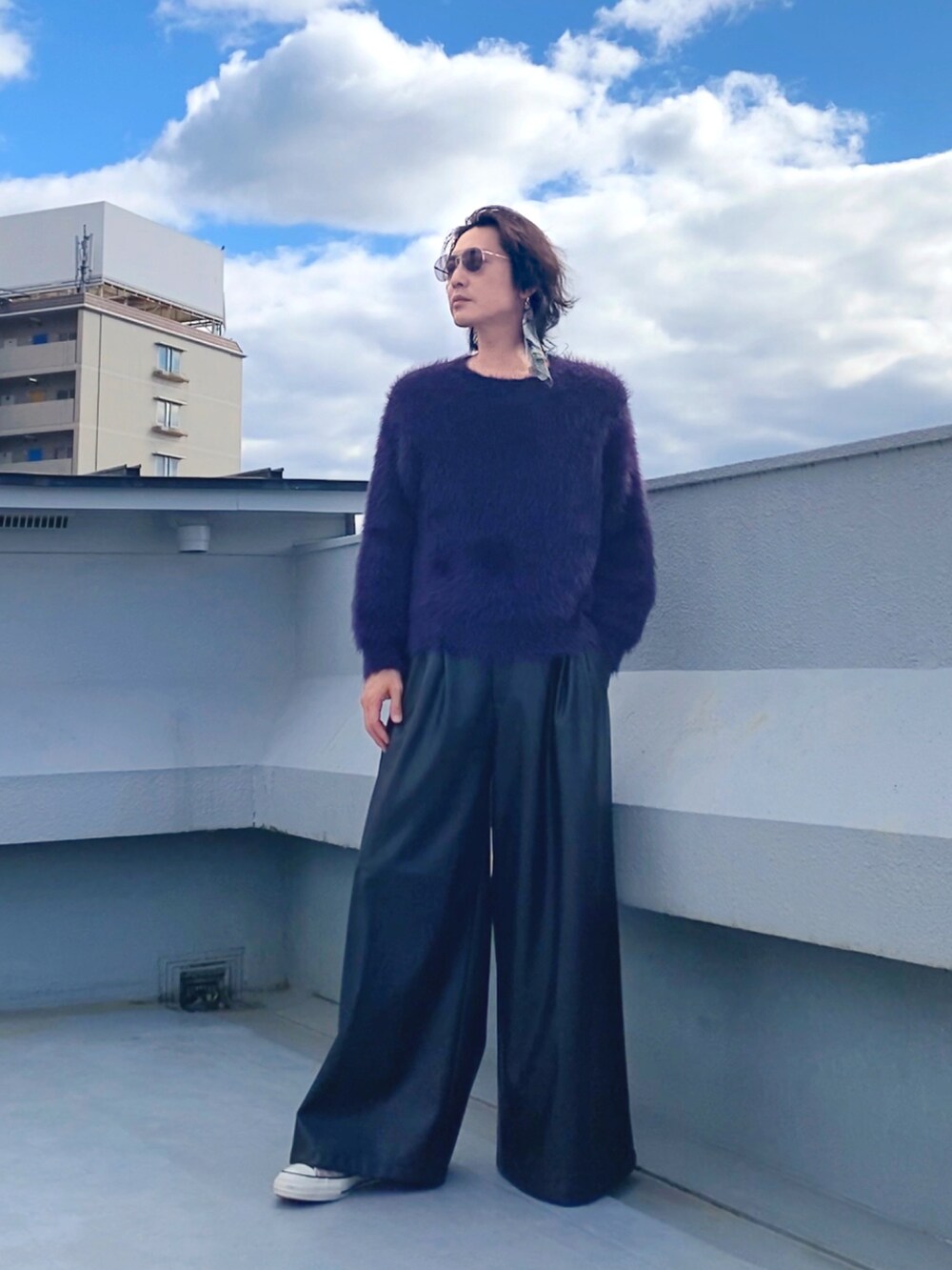 パープル系のニット/セーター、ブラック系のその他パンツ、ベージュ系のスニーカーを着用したメンズの秋コーディネートの4枚目の写真