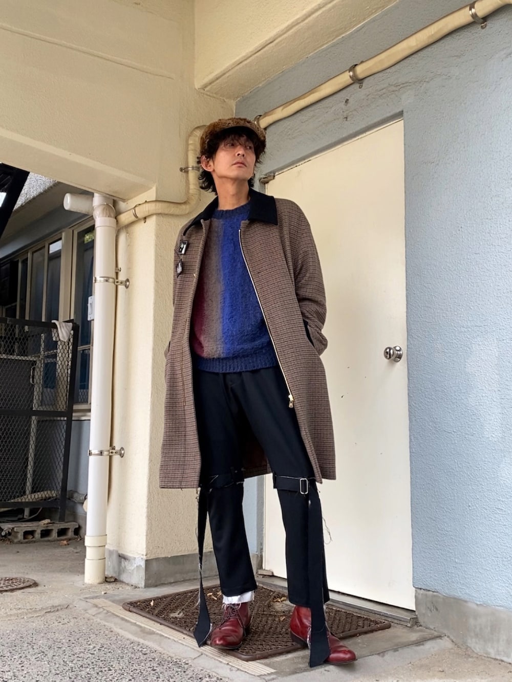 ブルー系のニット/セーター、ブラック系のその他パンツ、レッド系のドレスシューズを着用したメンズの冬コーディネートの2枚目の写真