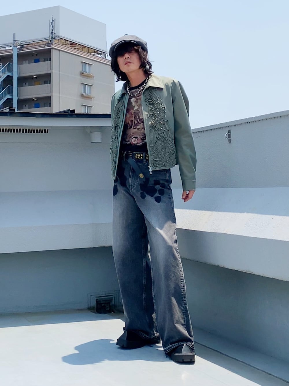 グリーン系のブルゾン、ブラック系のTシャツ/カットソー、ブラック系のデニムパンツを着用したメンズの夏コーディネートの2枚目の写真