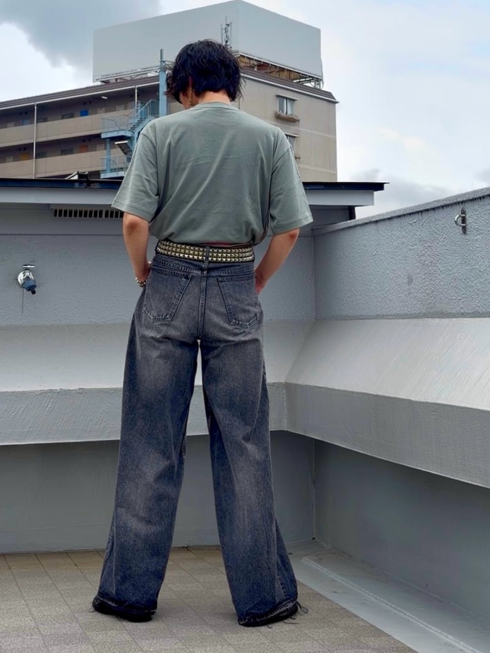 ブラック系のデニムパンツ、ブラック系のブーツ、グリーン系のTシャツ/カットソーを着用したメンズの夏コーディネートの5枚目の写真