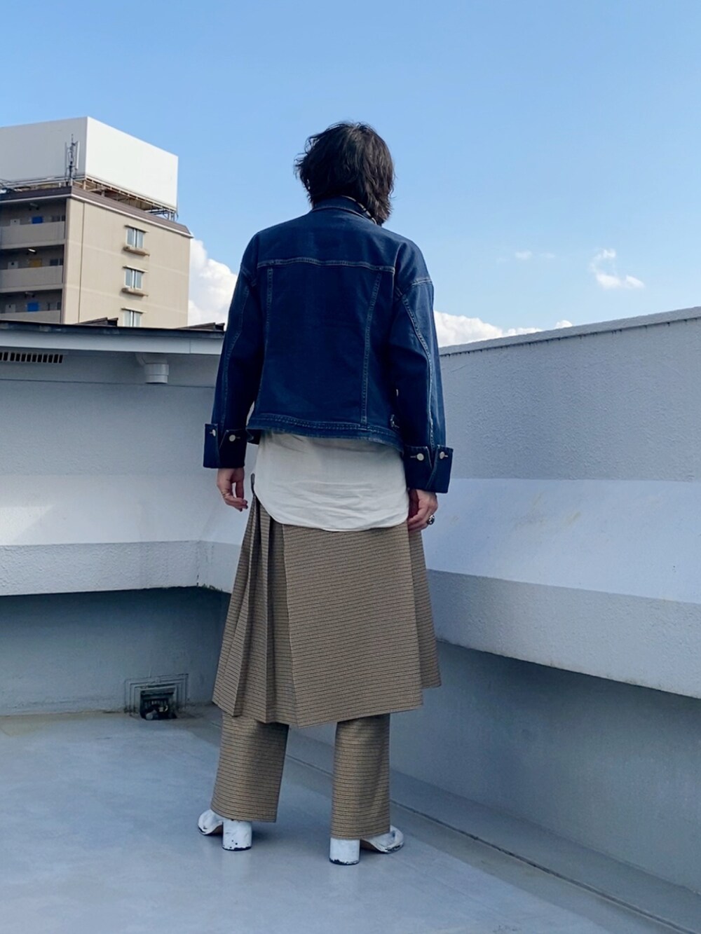 ブルー系のデニムジャケット、ベージュ系のスカート、ベージュ系のスラックスを着用したメンズの秋コーディネートの4枚目の写真