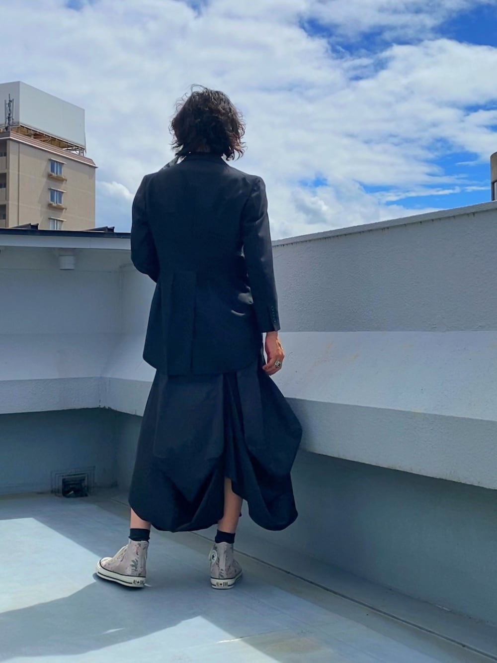 ブラック系のテーラードジャケット、ホワイト系のシャツ/ブラウス、ブラック系のスカートを着用したメンズの秋コーディネートの4枚目の写真