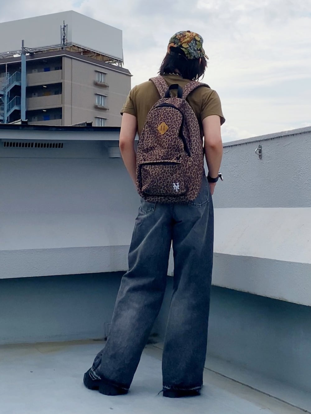 ブラック系のデニムパンツ、ベージュ系のTシャツ/カットソー、ブラック系のドレスシューズを着用したメンズの夏コーディネートの5枚目の写真