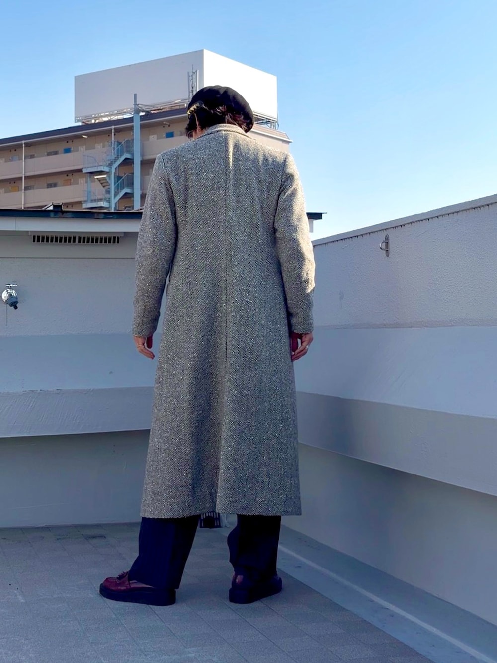 ベージュ系のチェスターコート、ブラック系のライダースジャケット、グレー系のスラックスを着用したメンズの冬コーディネートの4枚目の写真