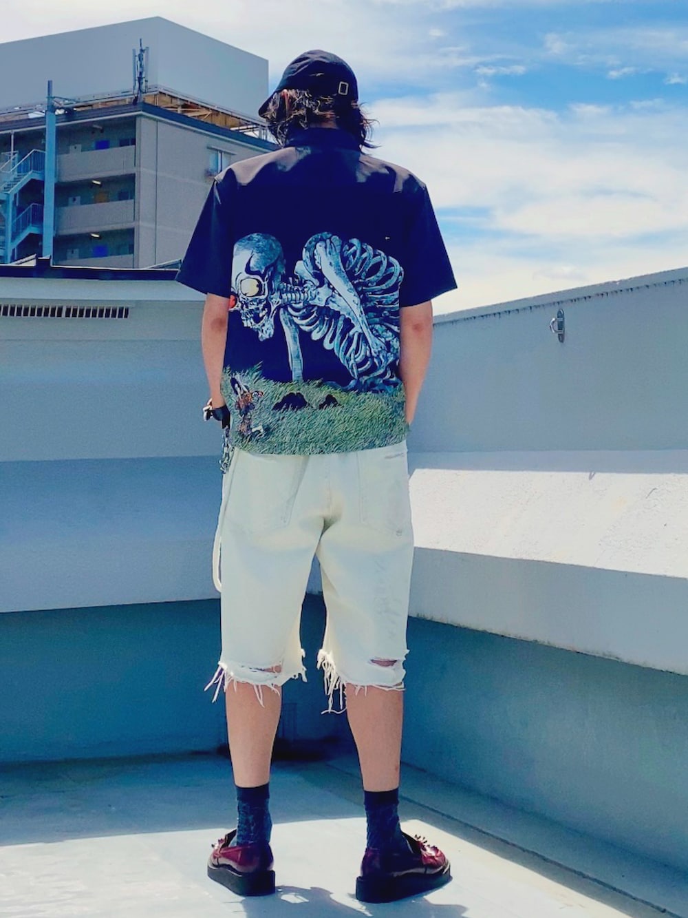 ホワイト系のデニムパンツ、ブラック系のシャツ/ブラウス、レッド系のローファーを着用したメンズの夏コーディネートの4枚目の写真