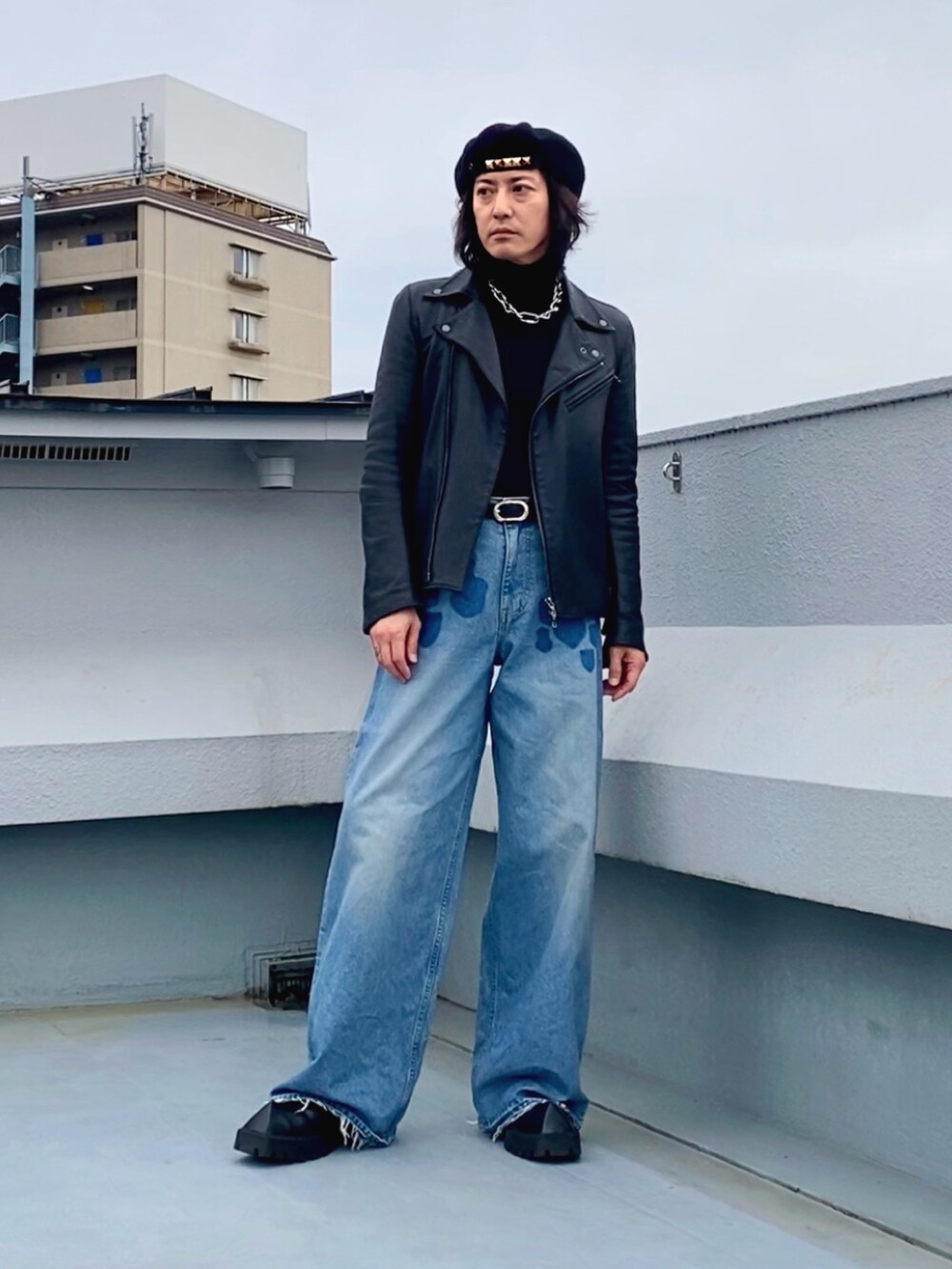 ブラック系のライダースジャケット、ブラック系のニット/セーター、ブルー系のデニムパンツを着用したメンズの春コーディネートの3枚目の写真