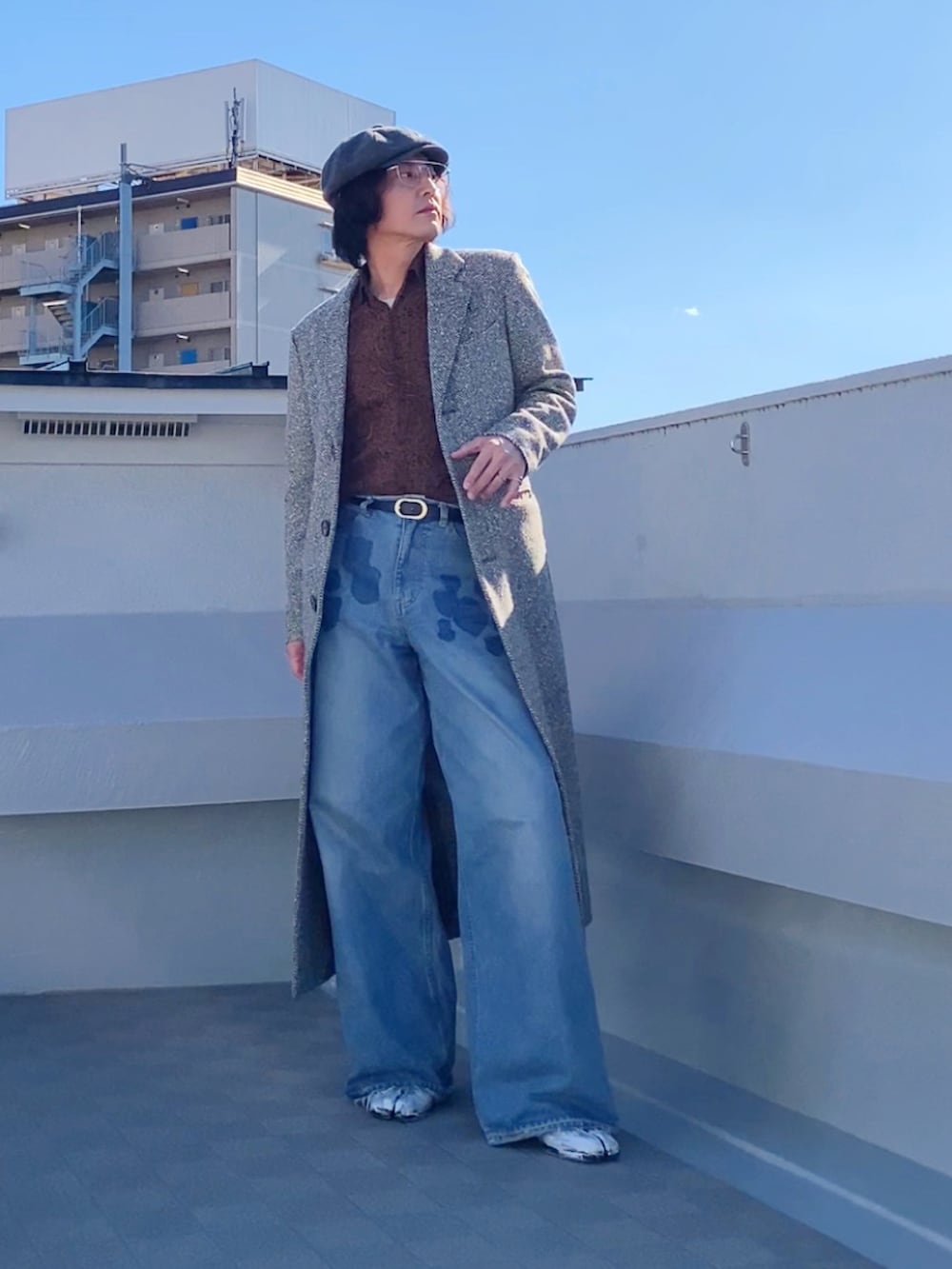 ブルー系のデニムパンツ、ブラウン系のシャツ/ブラウス、ベージュ系のチェスターコートを着用したメンズの秋コーディネートの3枚目の写真