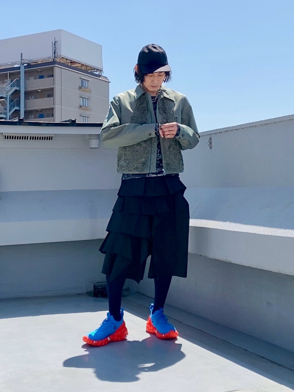 グリーン系のブルゾン、ブラック系のTシャツ/カットソー、ブラック系のパンツを着用したメンズの春コーディネートの2枚目の写真