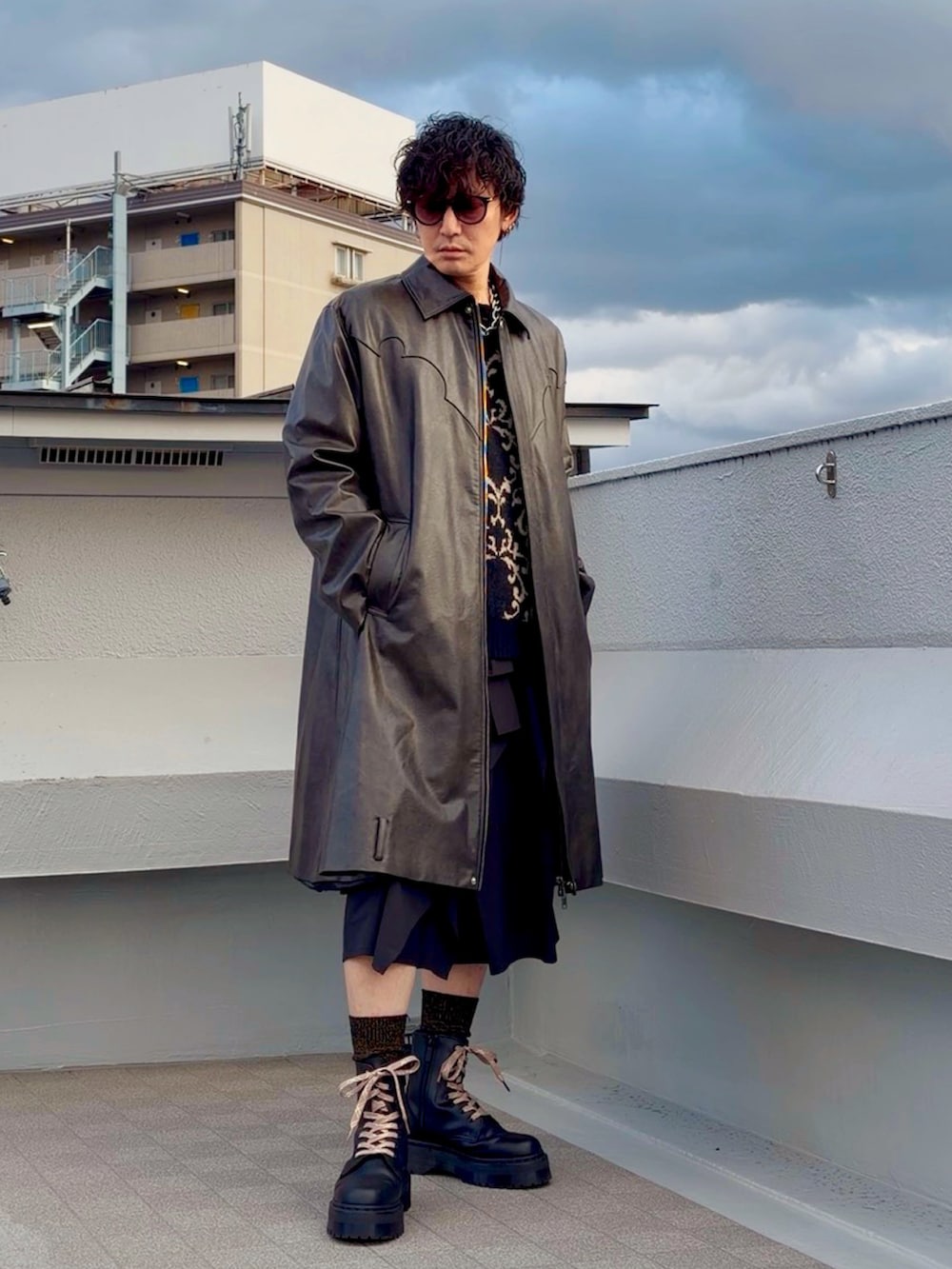 ブラック系のブーツ、ブラック系のニット/セーター、ブラウン系のジャケット/アウターを着用したメンズの冬コーディネートの5枚目の写真