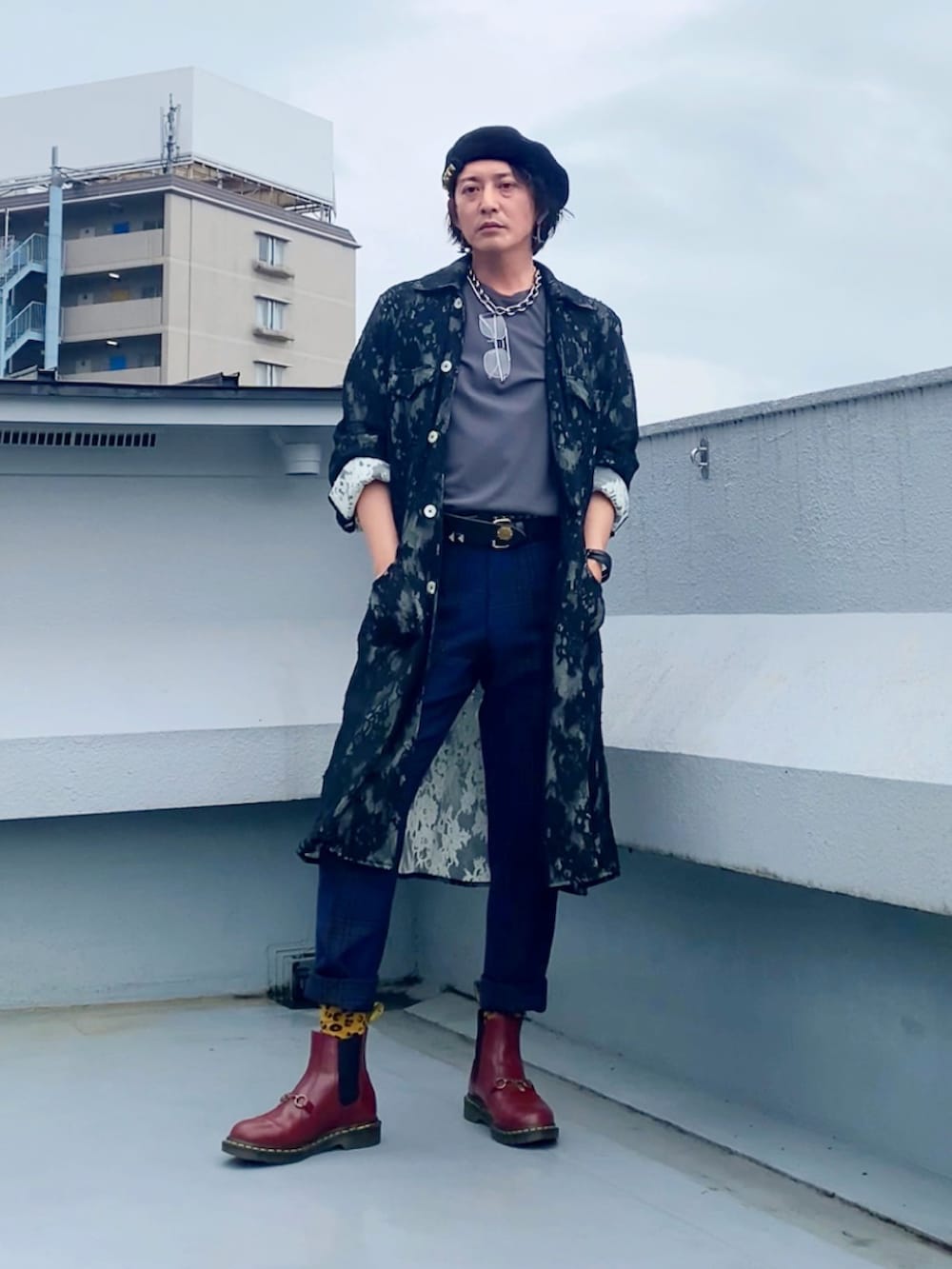 グレー系のTシャツ/カットソー、ブラック系のステンカラーコート、グリーン系のスラックスを着用したメンズの秋コーディネートの2枚目の写真