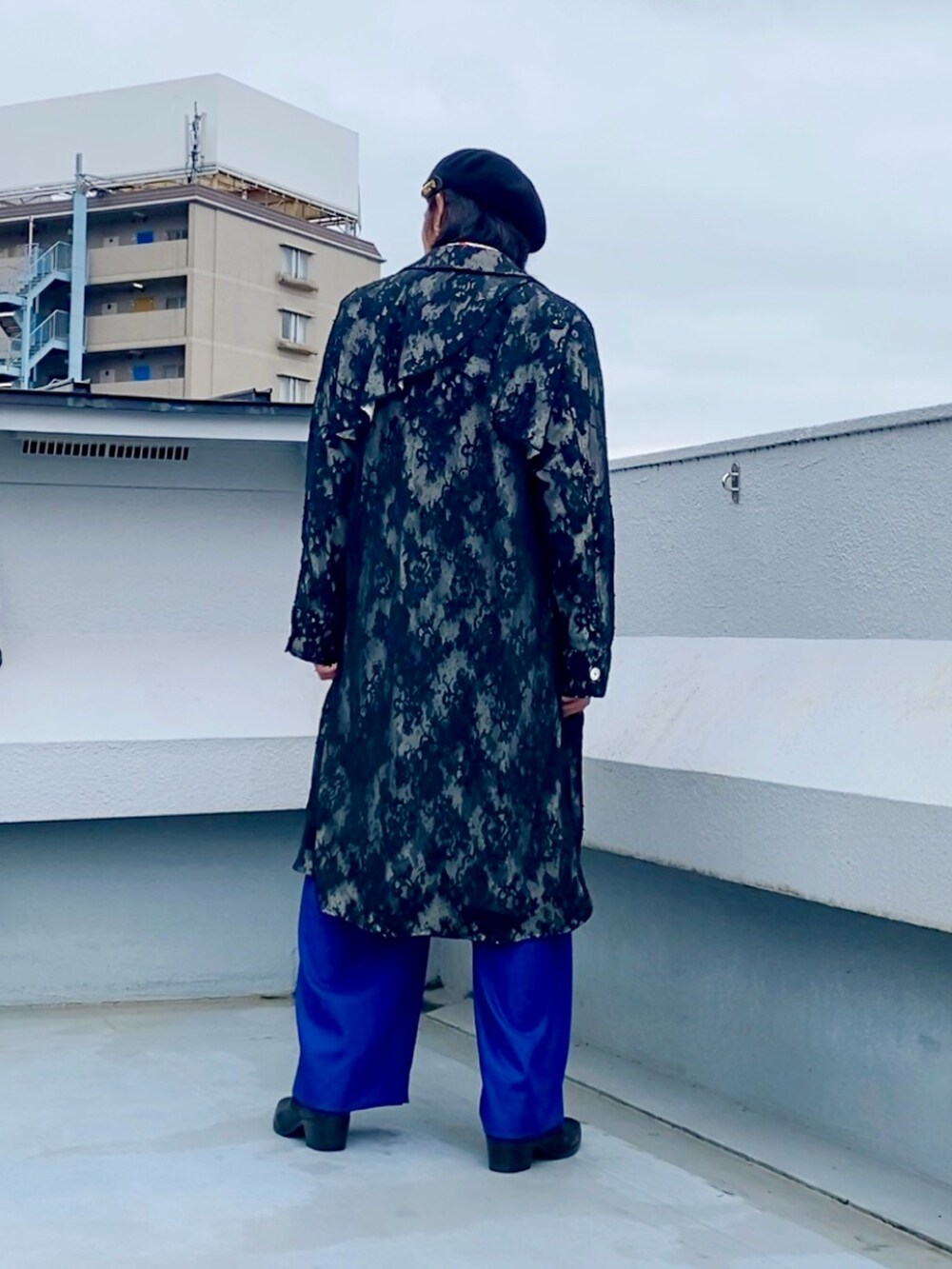 ホワイト系のシャツ/ブラウス、ブラック系のステンカラーコート、ブルー系のスラックスを着用したメンズの春コーディネートの5枚目の写真