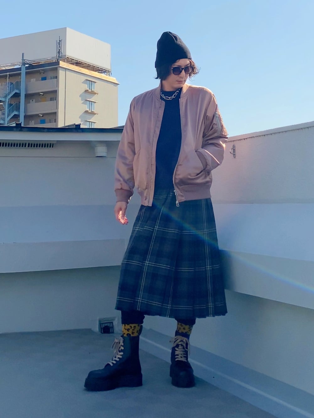 ブラック系のブーツ、パープル系のニット/セーター、ピンク系のMA-1を着用したメンズの冬コーディネートの2枚目の写真