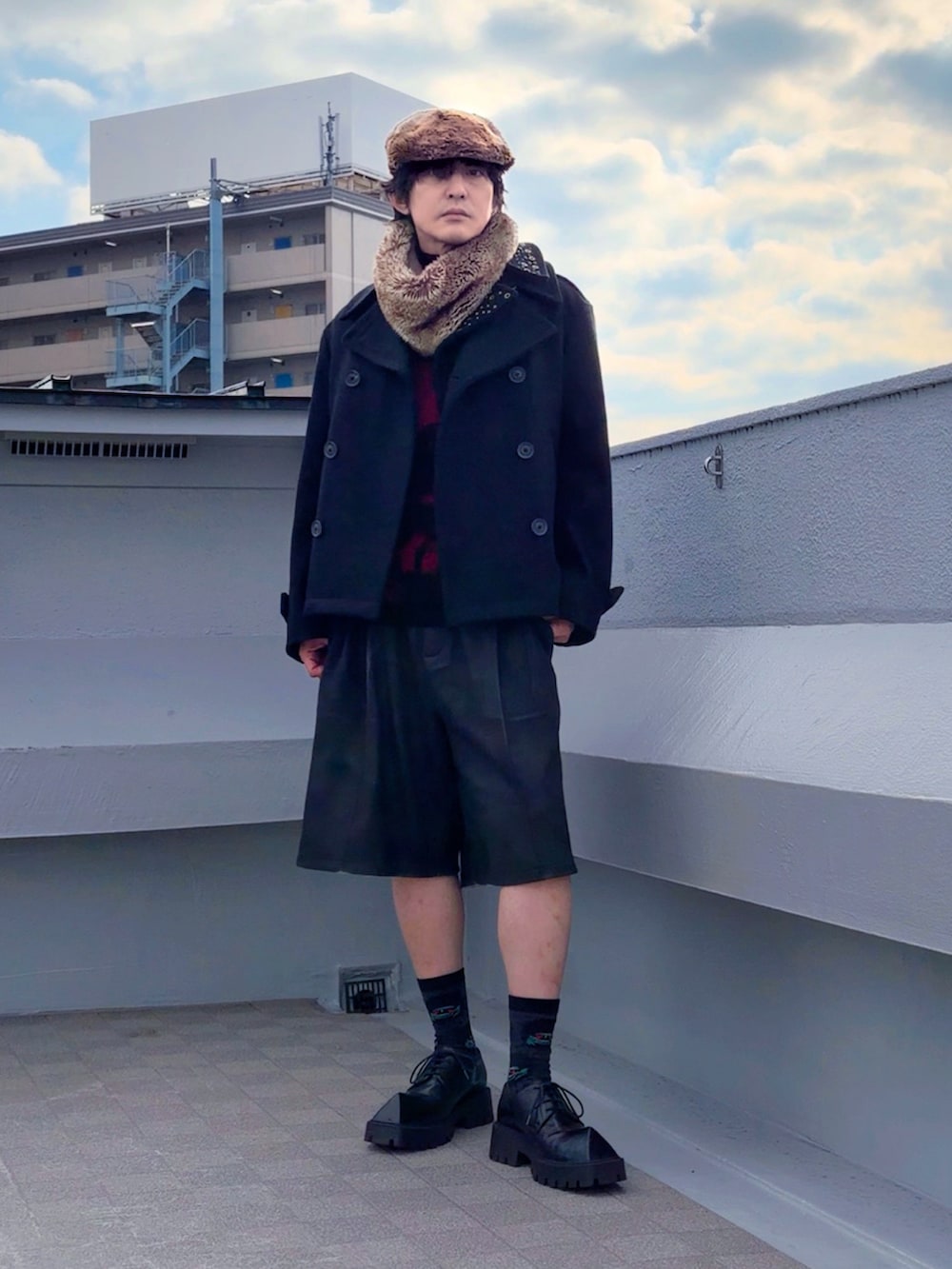 レッド系のニット/セーター、ブラック系のピーコート、ブラック系のその他パンツを着用したメンズの冬コーディネートの3枚目の写真