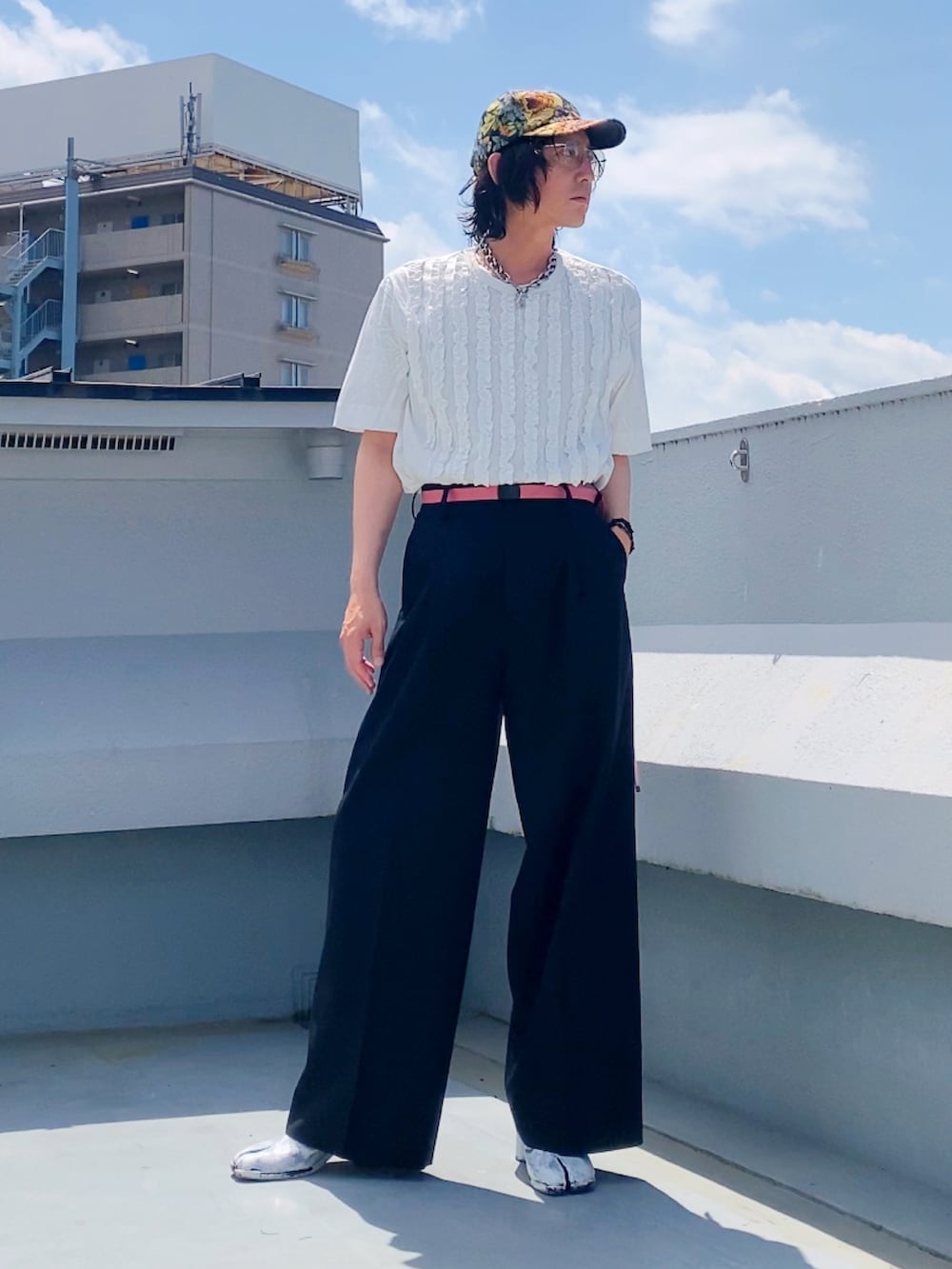 ホワイト系のTシャツ/カットソー、ブラック系のスラックス、ホワイト系のブーツを着用したメンズの夏コーディネートの3枚目の写真