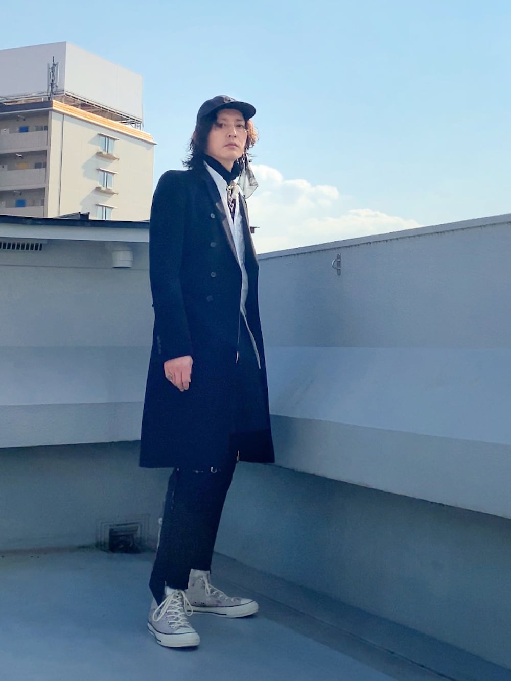 ブラック系のチェスターコート、ホワイト系のシャツ/ブラウス、ブラック系のニット/セーターを着用したメンズの冬コーディネートの5枚目の写真