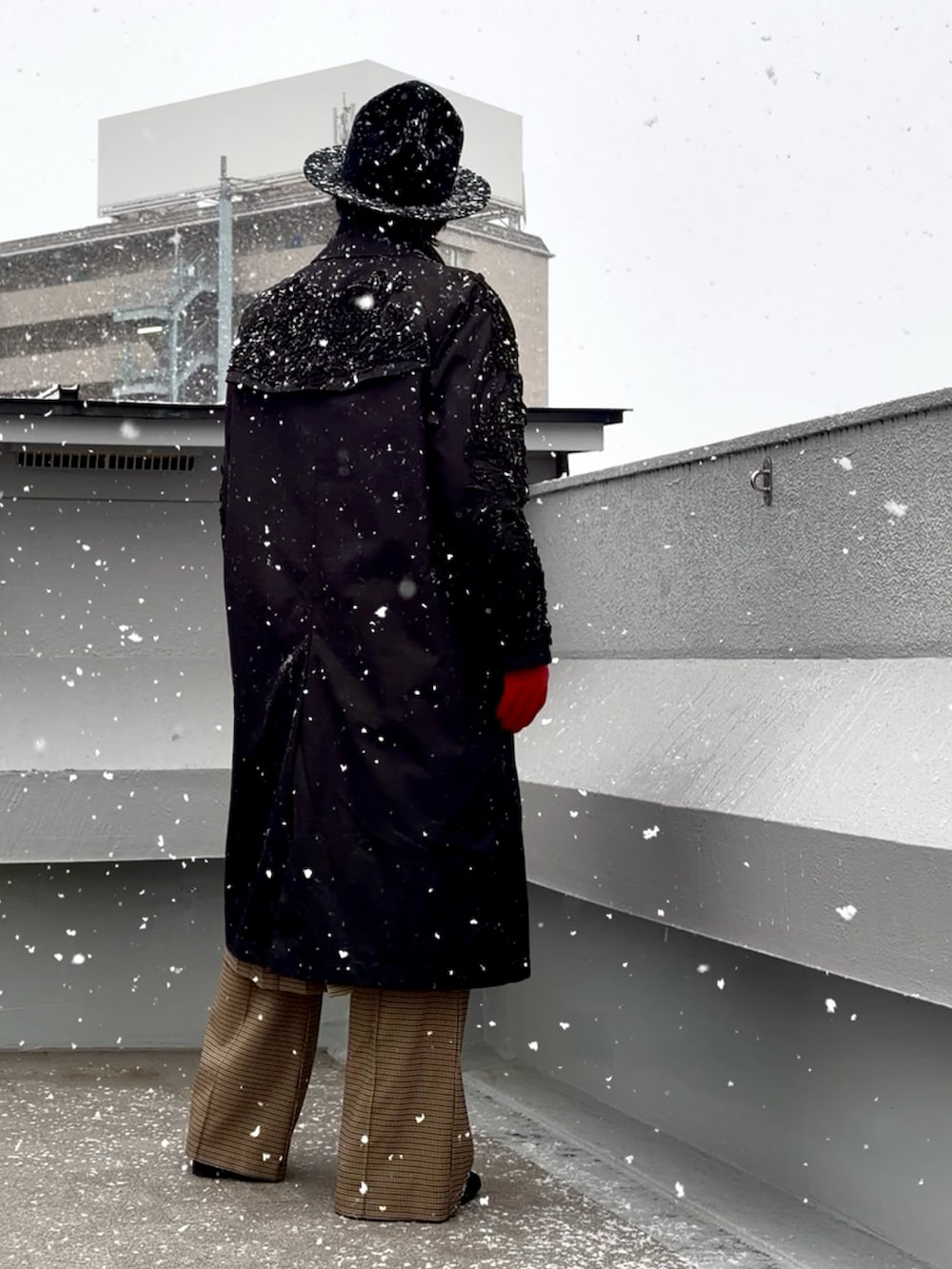 ブラック系のニット/セーター、ブラック系のステンカラーコート、ブラウン系のテーラードジャケットを着用したメンズの冬コーディネートの5枚目の写真