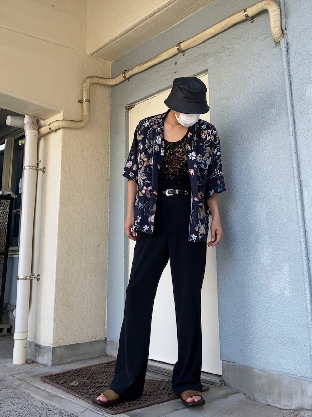 ブラック系のシャツ/ブラウス、ブラック系のスラックス、ブラウン系のサンダルを着用したメンズの夏コーディネートの2枚目の写真