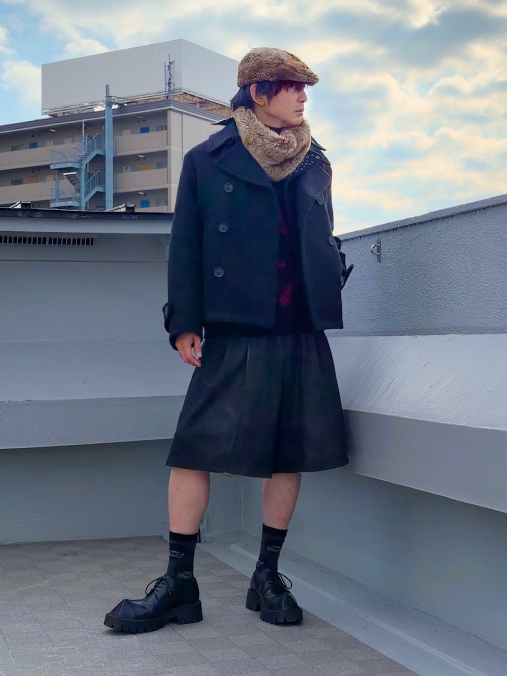 レッド系のニット/セーター、ブラック系のピーコート、ブラック系のその他パンツを着用したメンズの冬コーディネートの2枚目の写真