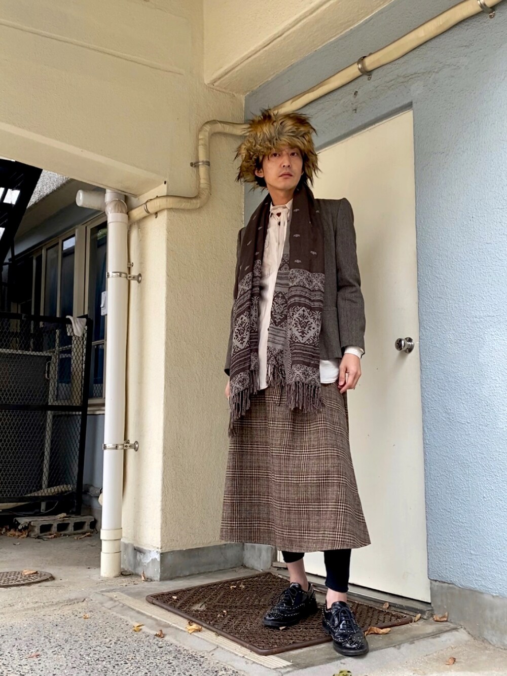 ブラウン系のテーラードジャケット、ブラック系のドレスシューズ、ブラウン系のスカートを着用したメンズの冬コーディネートの4枚目の写真