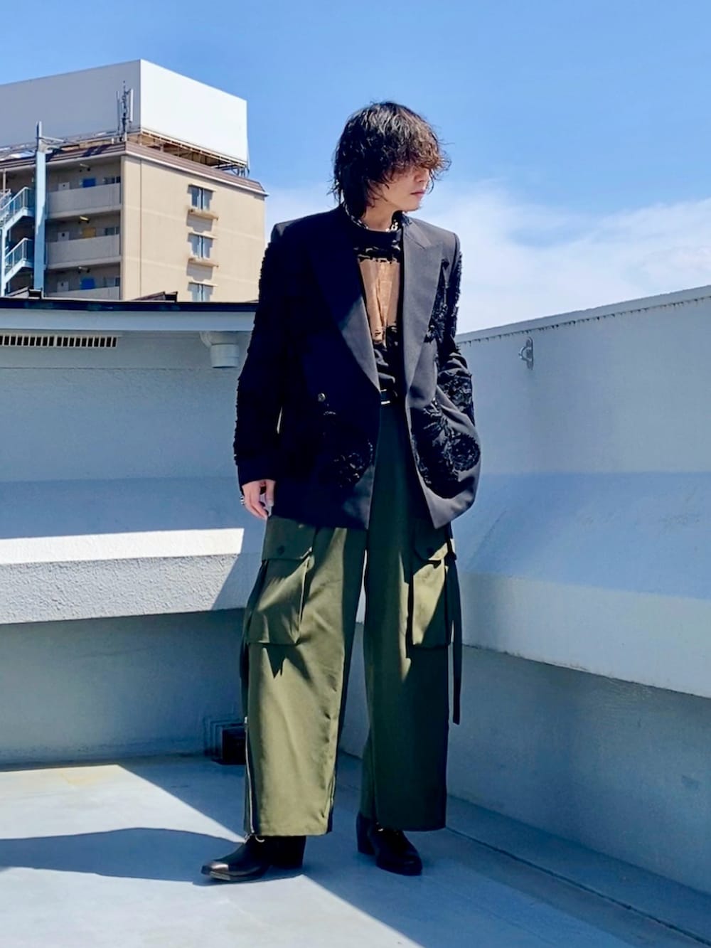 ブラック系のテーラードジャケット、ブラック系のTシャツ/カットソー、グリーン系のカーゴパンツを着用したメンズの春コーディネートの2枚目の写真