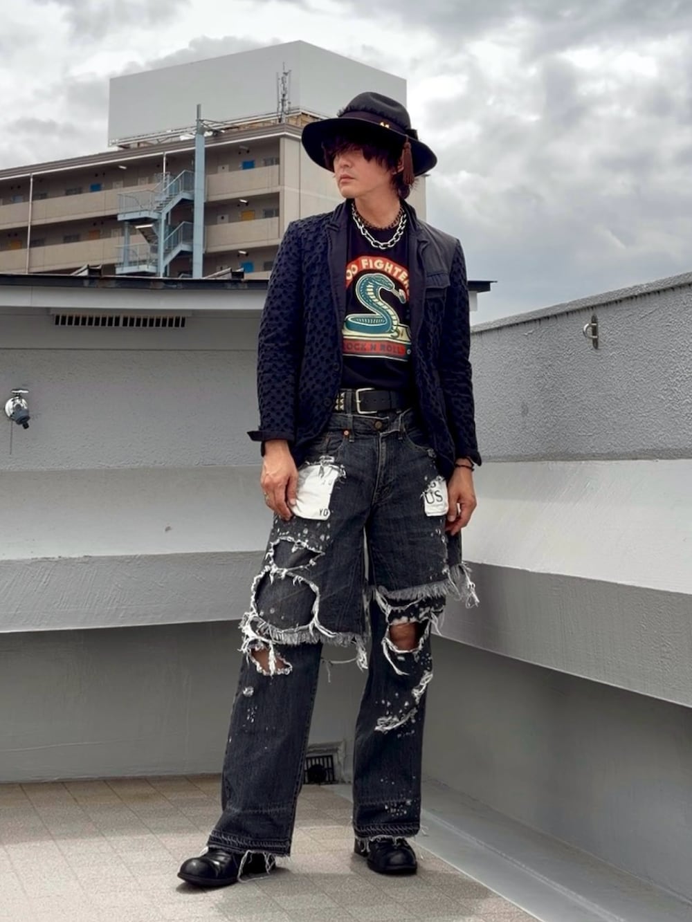 ブラック系のTシャツ/カットソー、ブルー系のテーラードジャケット、ブラック系のデニムパンツを着用したメンズの夏コーディネートの3枚目の写真