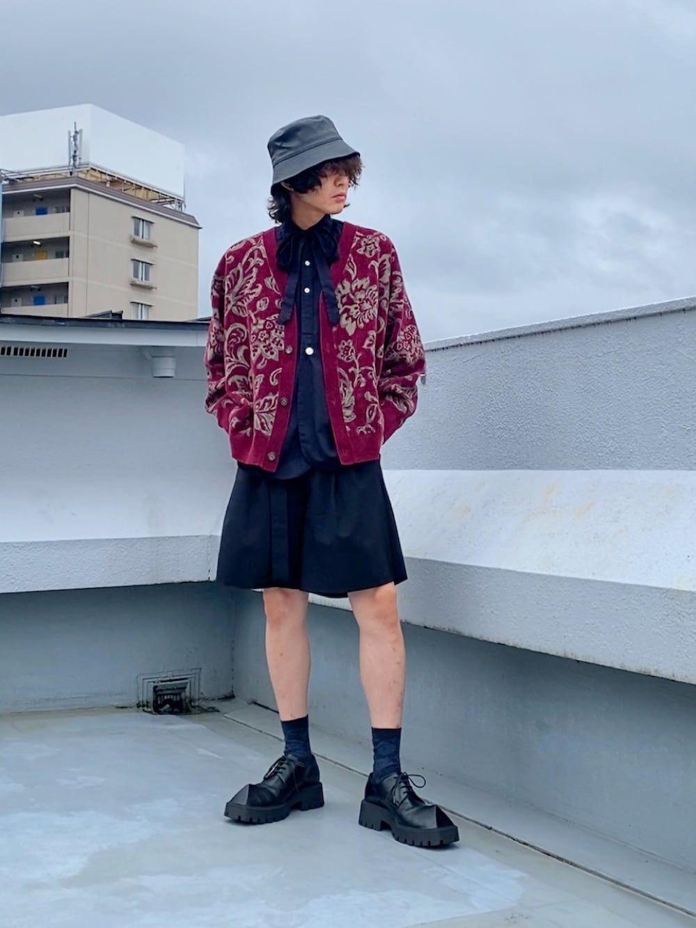 レッド系のカーディガン/ボレロ、ブラック系のシャツ/ブラウス、ブラック系のスラックスを着用したメンズの秋コーディネートの4枚目の写真