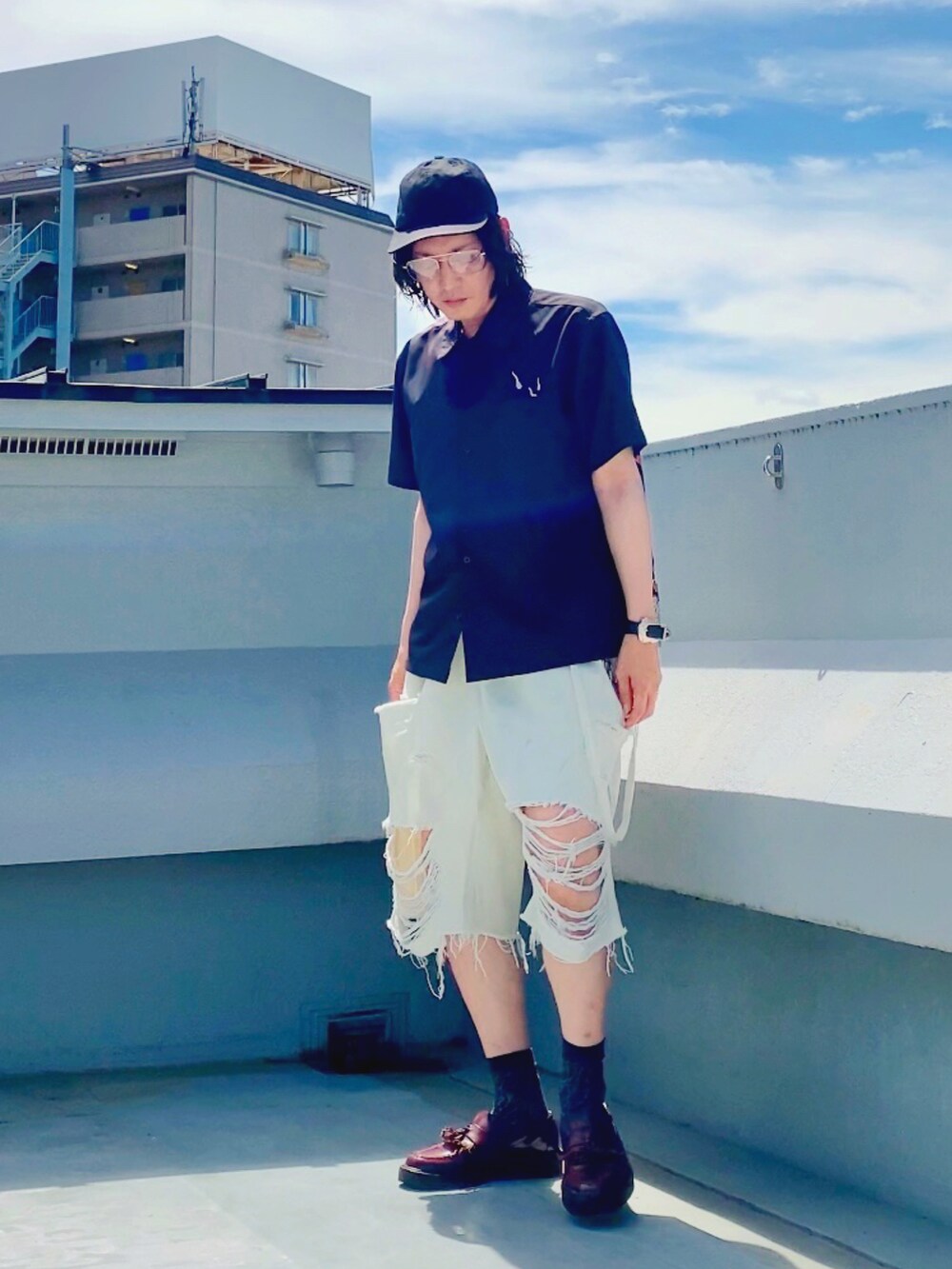 ホワイト系のデニムパンツ、ブラック系のシャツ/ブラウス、レッド系のローファーを着用したメンズの夏コーディネートの2枚目の写真