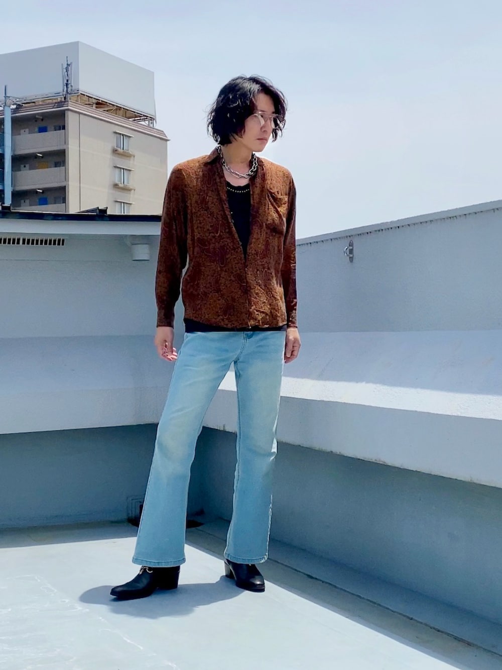 ブラウン系のシャツ/ブラウス、ブラック系のタンクトップ、ブルー系のデニムパンツを着用したメンズの春コーディネートの3枚目の写真