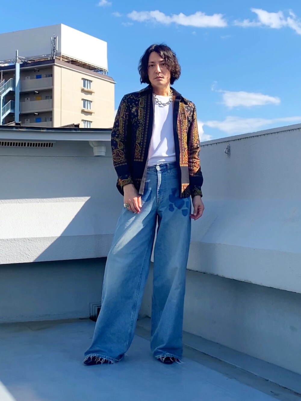 グレー系のTシャツ/カットソー、ブルー系のデニムパンツ、ブラック系のブーツを着用したメンズの秋コーディネートの2枚目の写真