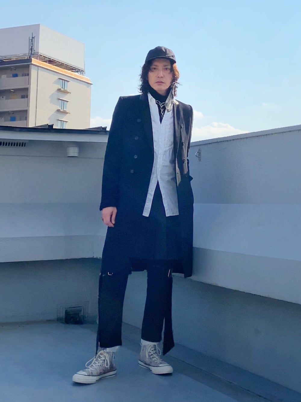 ブラック系のチェスターコート、ホワイト系のシャツ/ブラウス、ブラック系のニット/セーターを着用したメンズの冬コーディネートの3枚目の写真