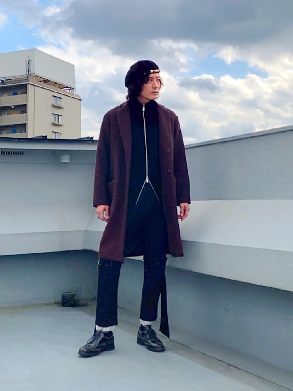 レッド系のチェスターコート、ブラック系のニット/セーター、ブラック系のその他パンツを着用したメンズの冬コーディネートの4枚目の写真