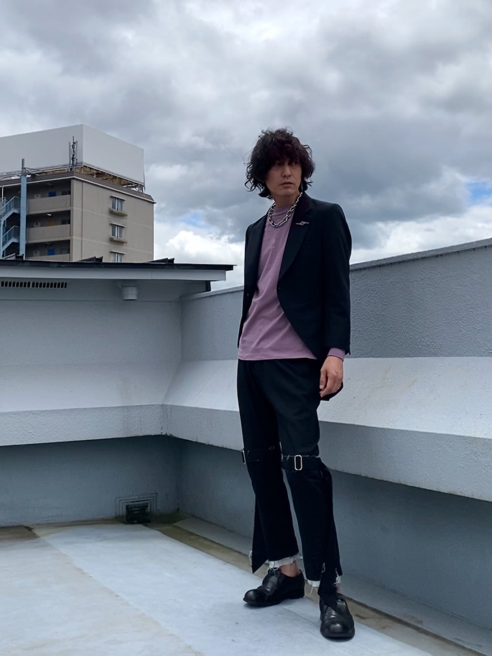 ブラック系のテーラードジャケット、ピンク系のTシャツ/カットソー、ブラック系のその他パンツを着用したメンズの春コーディネートの3枚目の写真